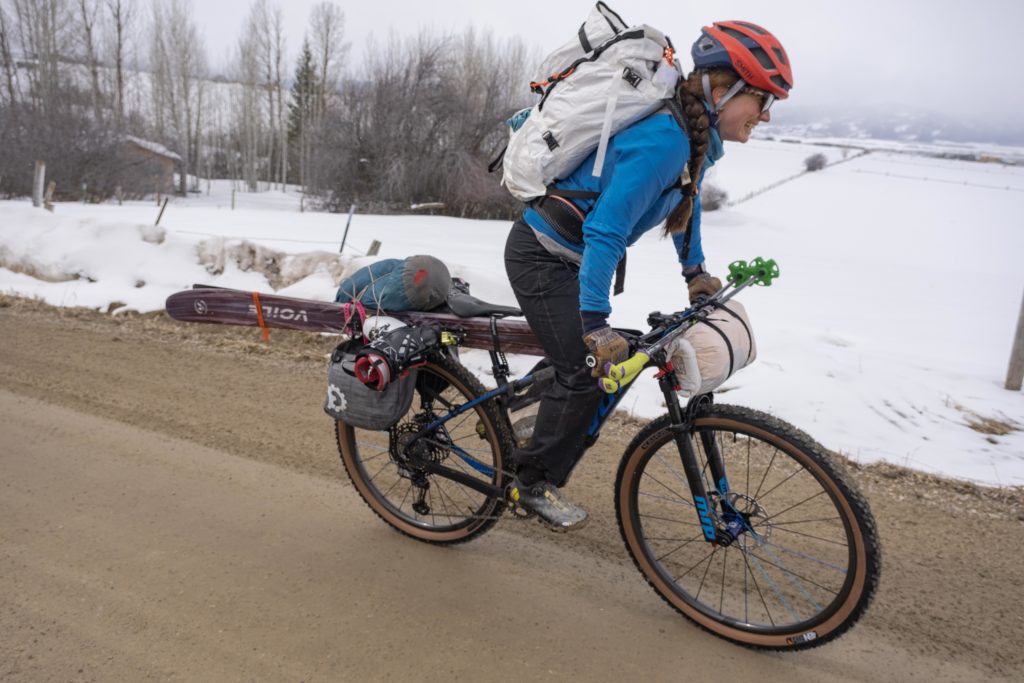 Kait Boyle crusing along with skis strapped to the bike.