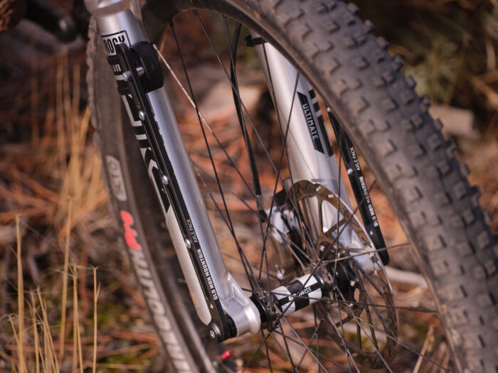 Suspension fork mounted cargo cage adapter, Axle Pack, mounted on a full-suspension mountain bike