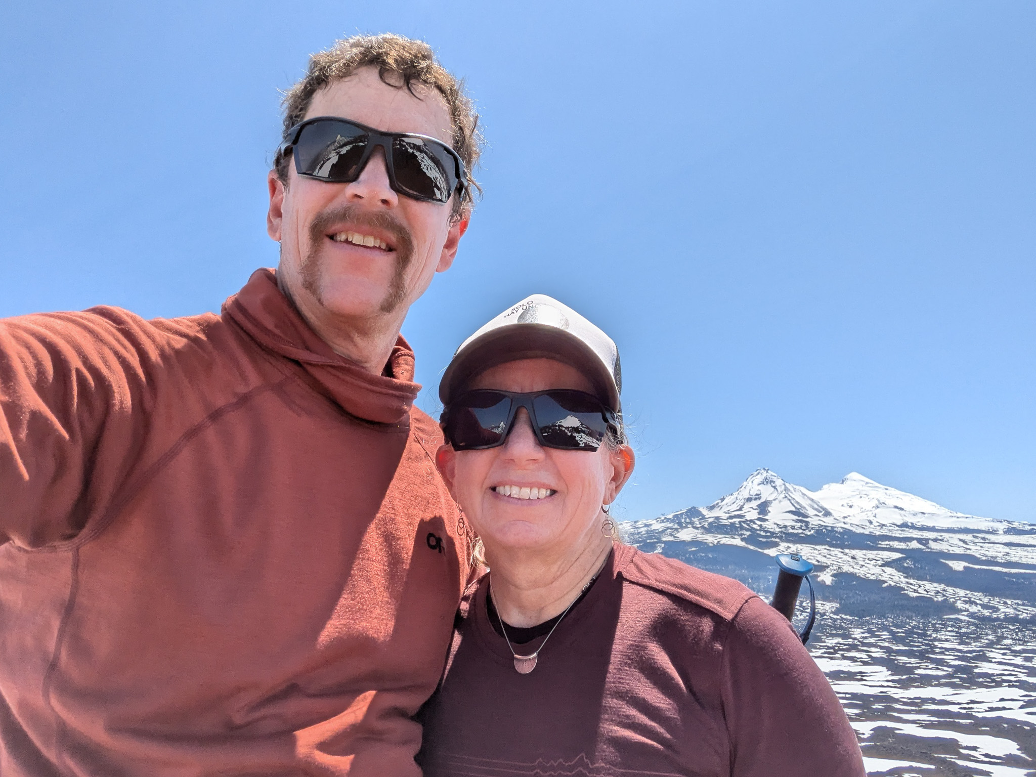 Chris and Katy smiling with Sisters mountains in background.