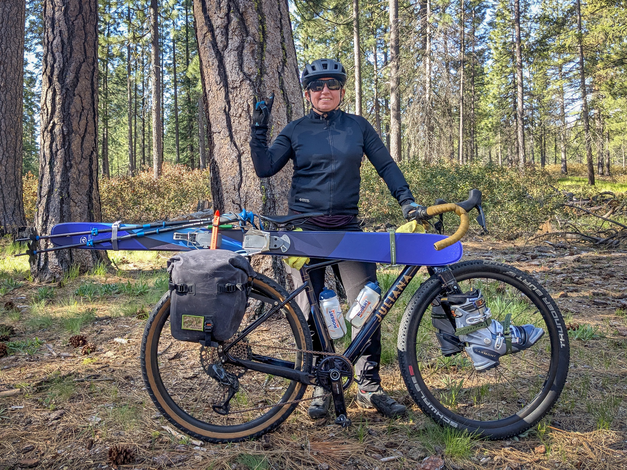 Katy standing with her bike with skis and boots attached.