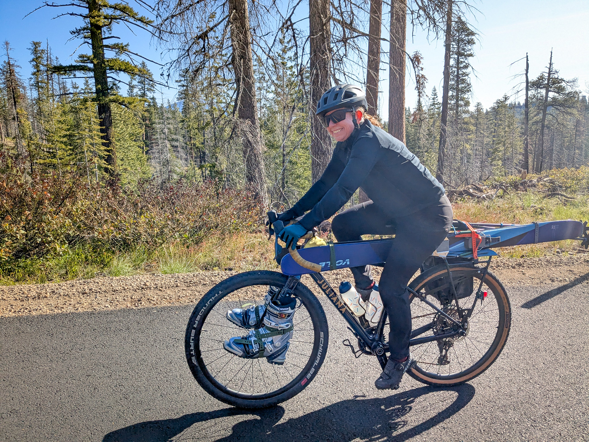 Katy riding her bike with skis and boots attached.
