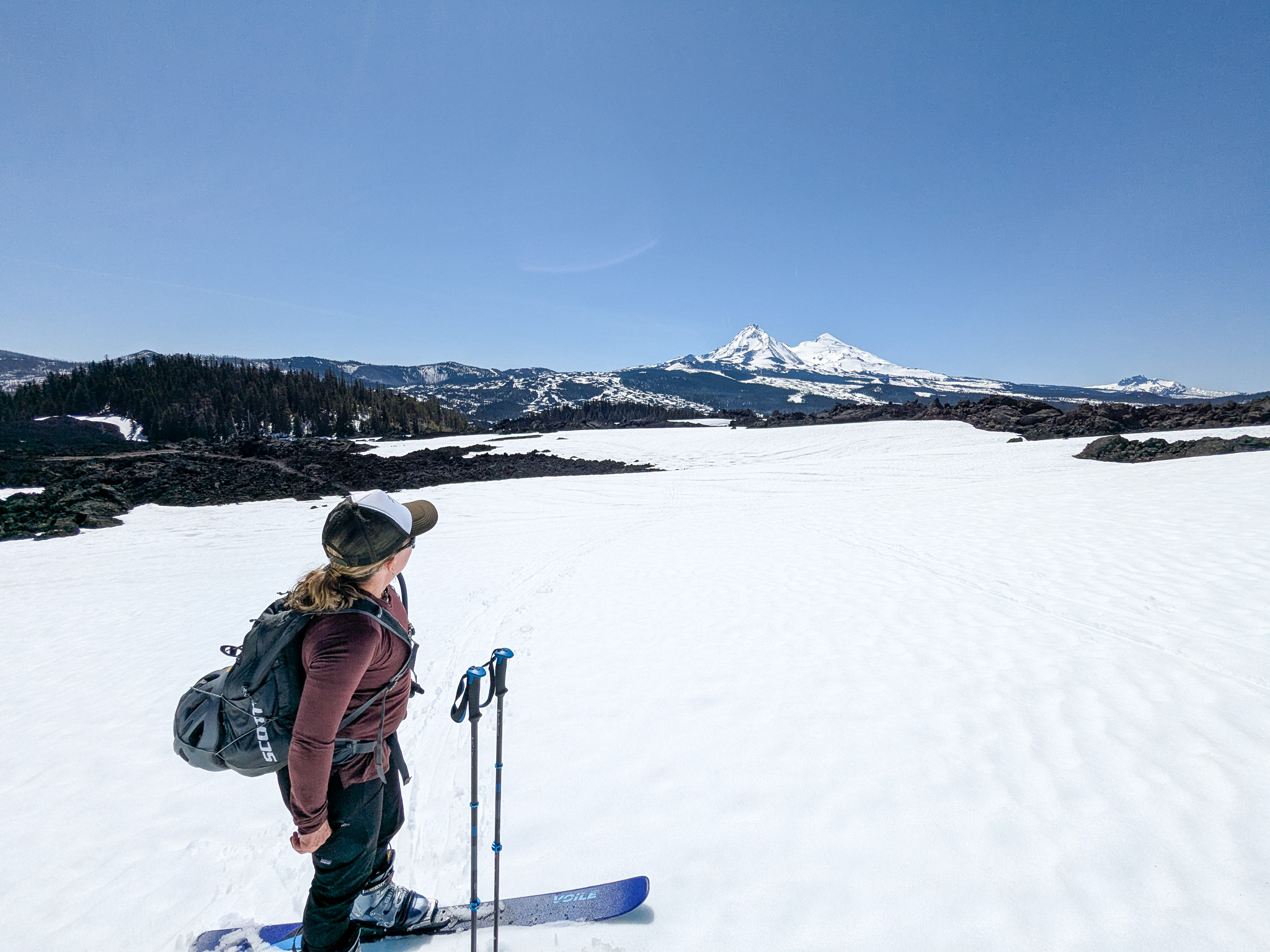 Katy standing on her skis looking out at the Sisters mountains.