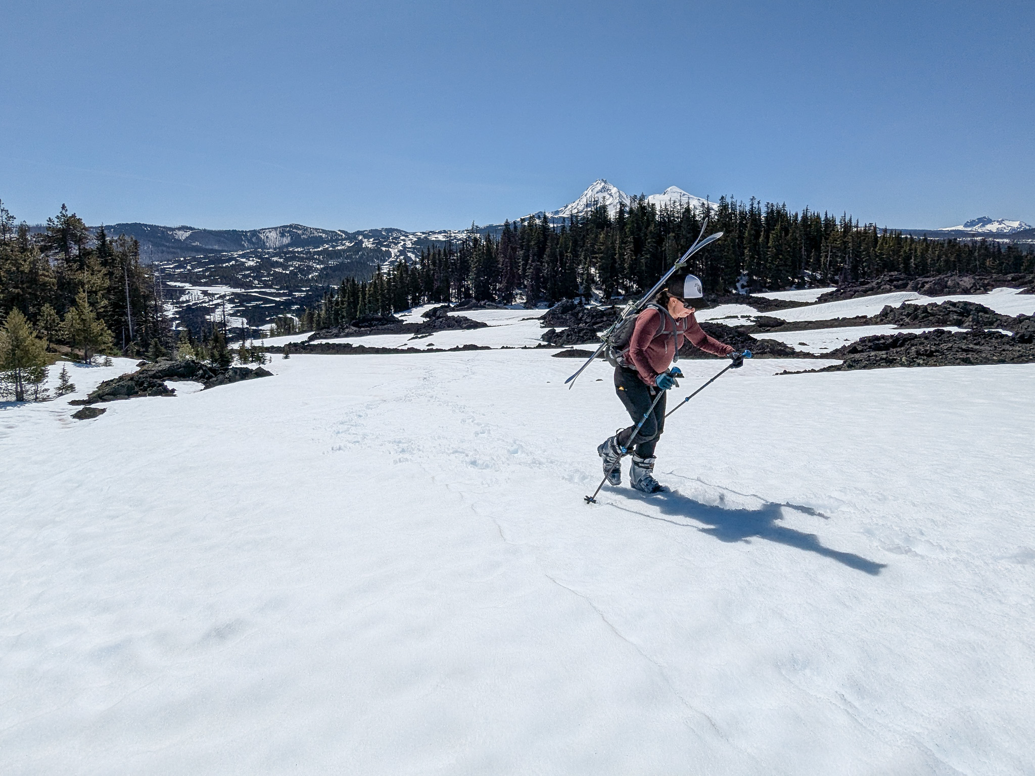Bike-ski-Chris-Katy-28 Katy hiking up a snowfield with skis on her back.