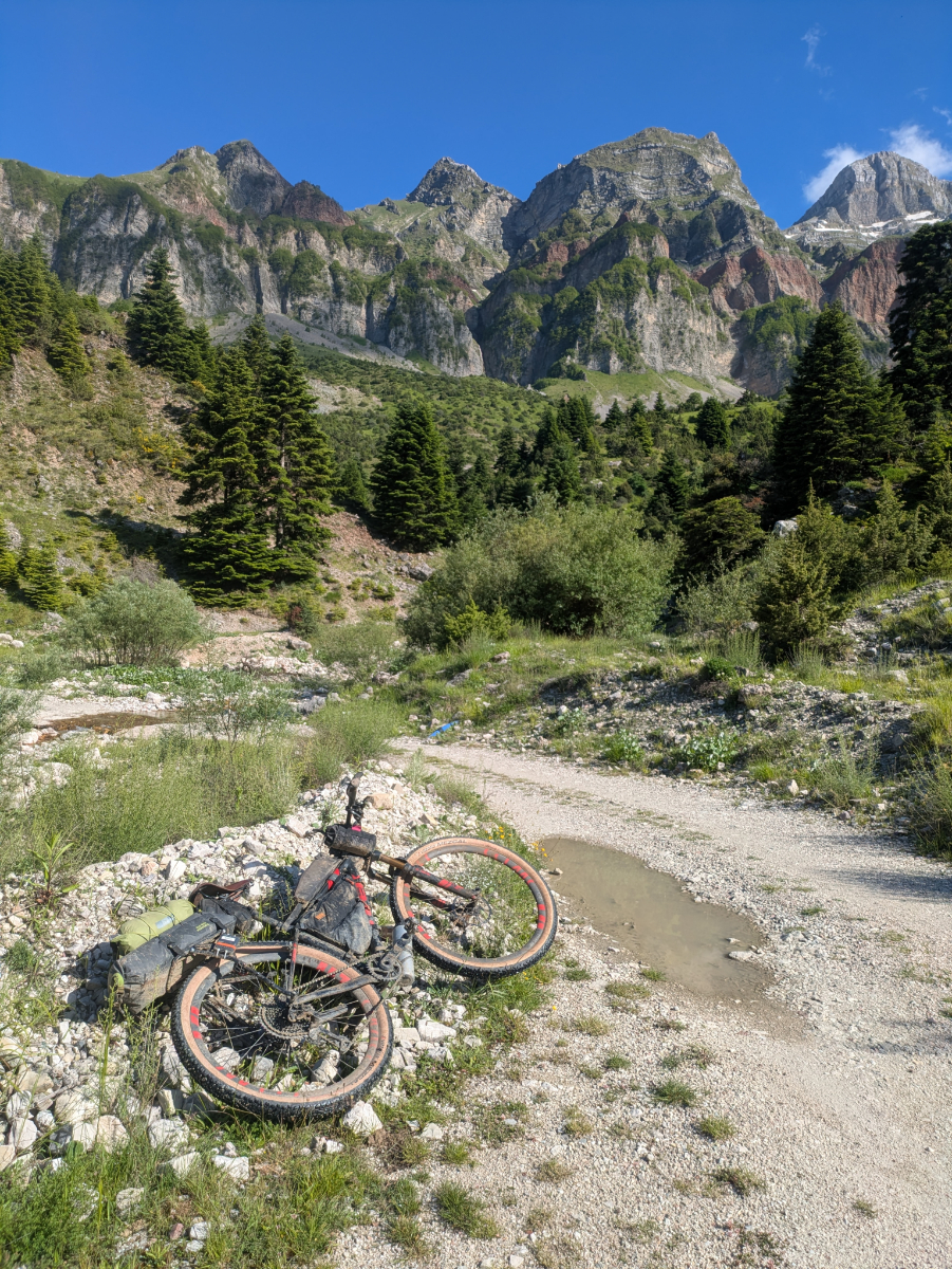 Jake.Dugdale.Hellenic.1 Jake's bike laying in foreground with mountains behind.