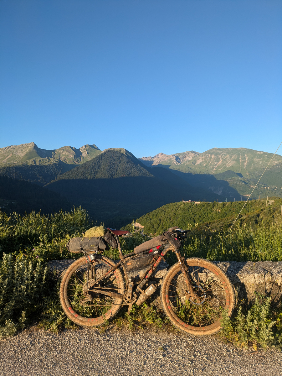 Jake.Dugdale.Hellenic.2 Jake's bike leaning against a wall in front of mountains.
