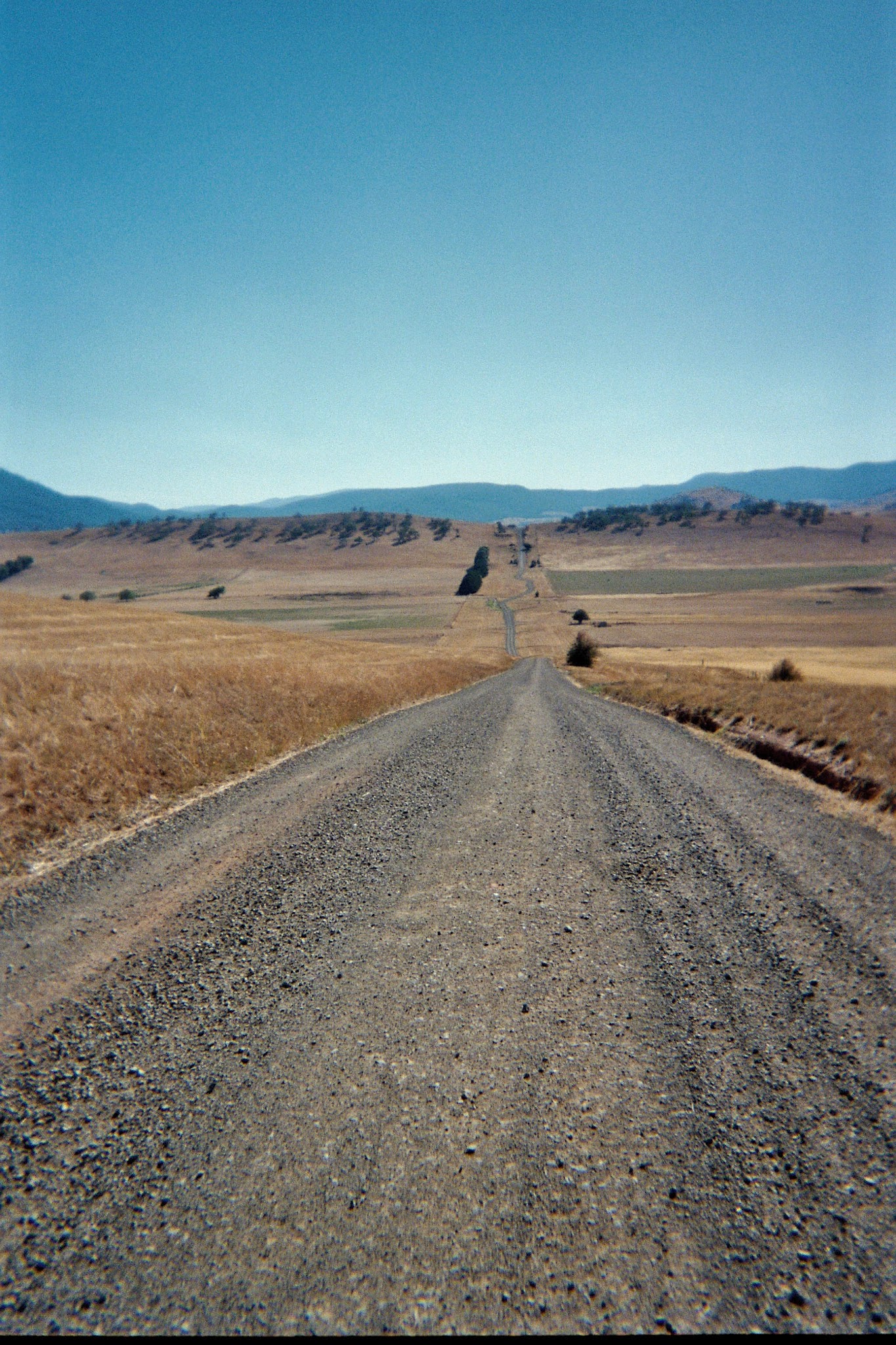 Long gravel road leading into the horizon.