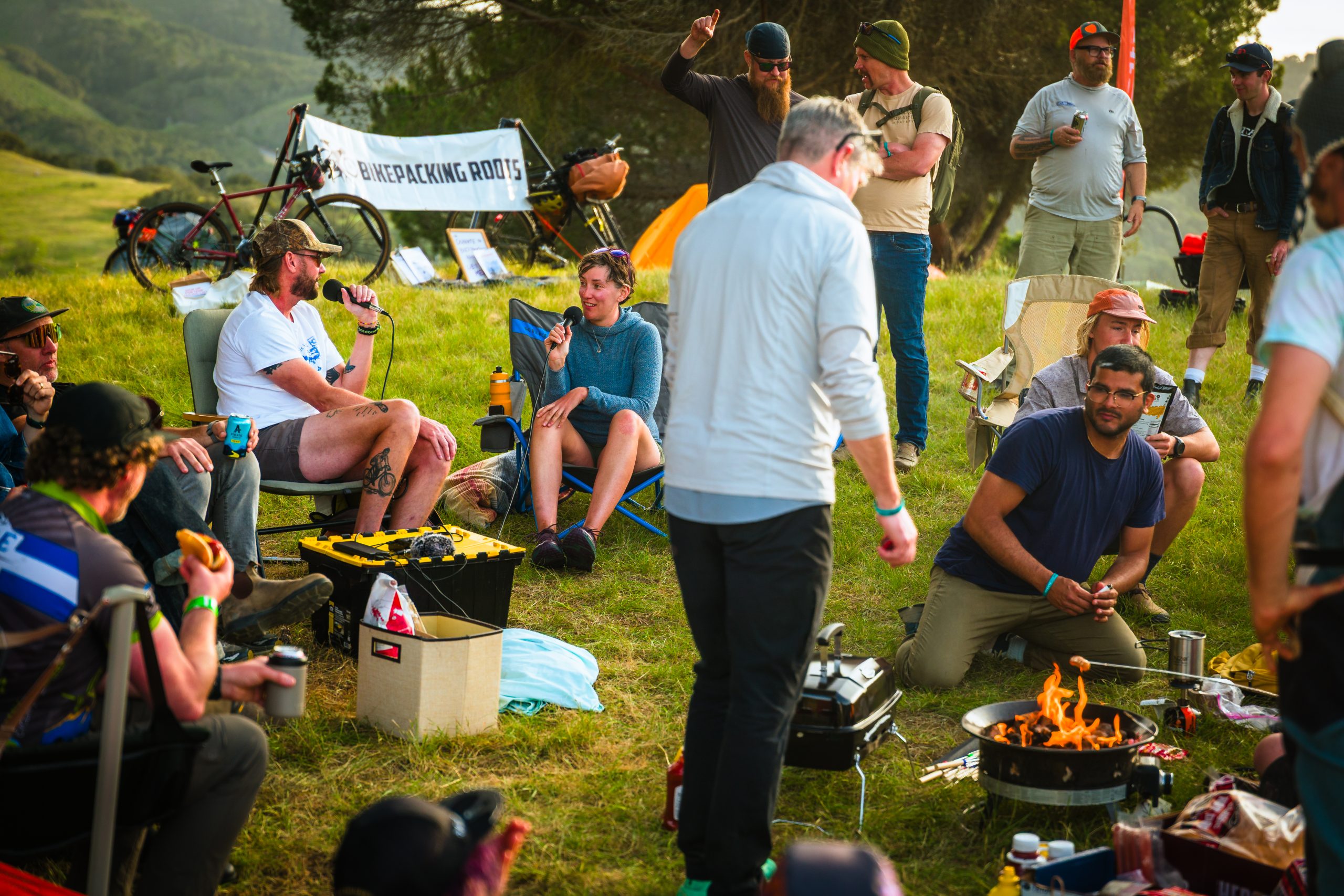 People gathered around firepit making smores with other conversations going on in the background.
