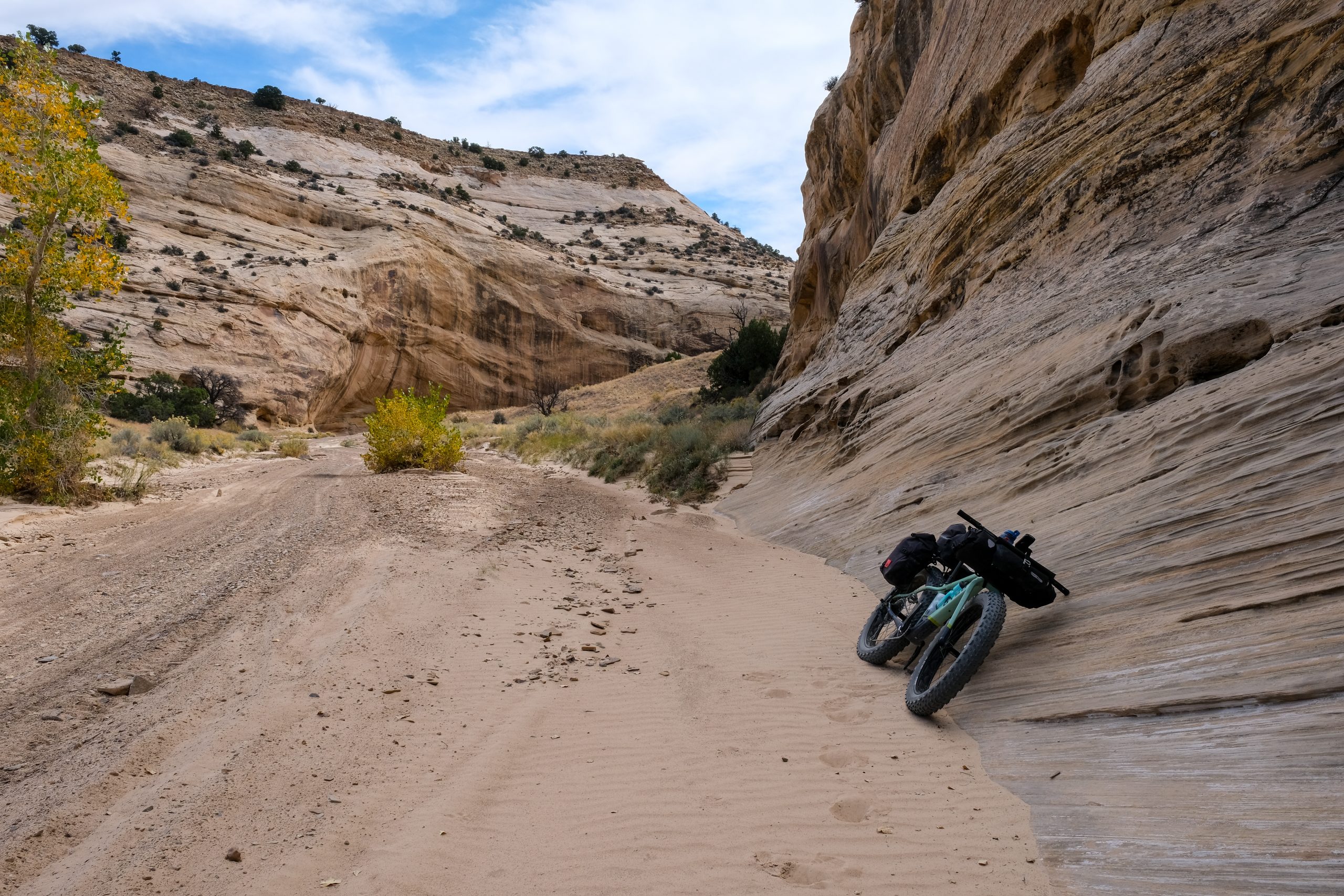 A bikepacking bike leaned against the solid rock in a dry wash in San Rafael Swell.