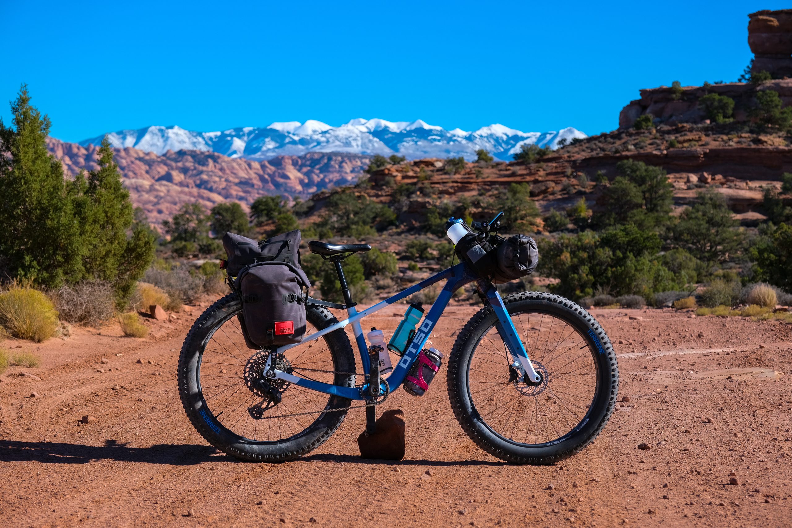 Bike parked on a desert dirt road and equipped with racks and bags for bikepacking.