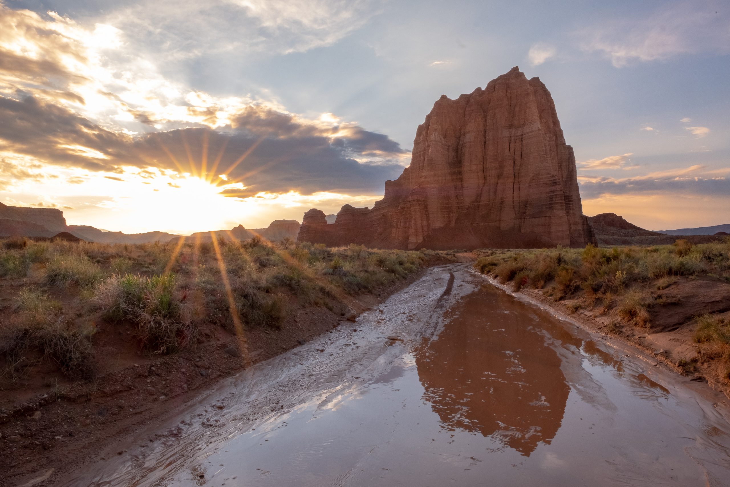 Sunset in Capitol Reef National Park with a muddy road in the foreground.